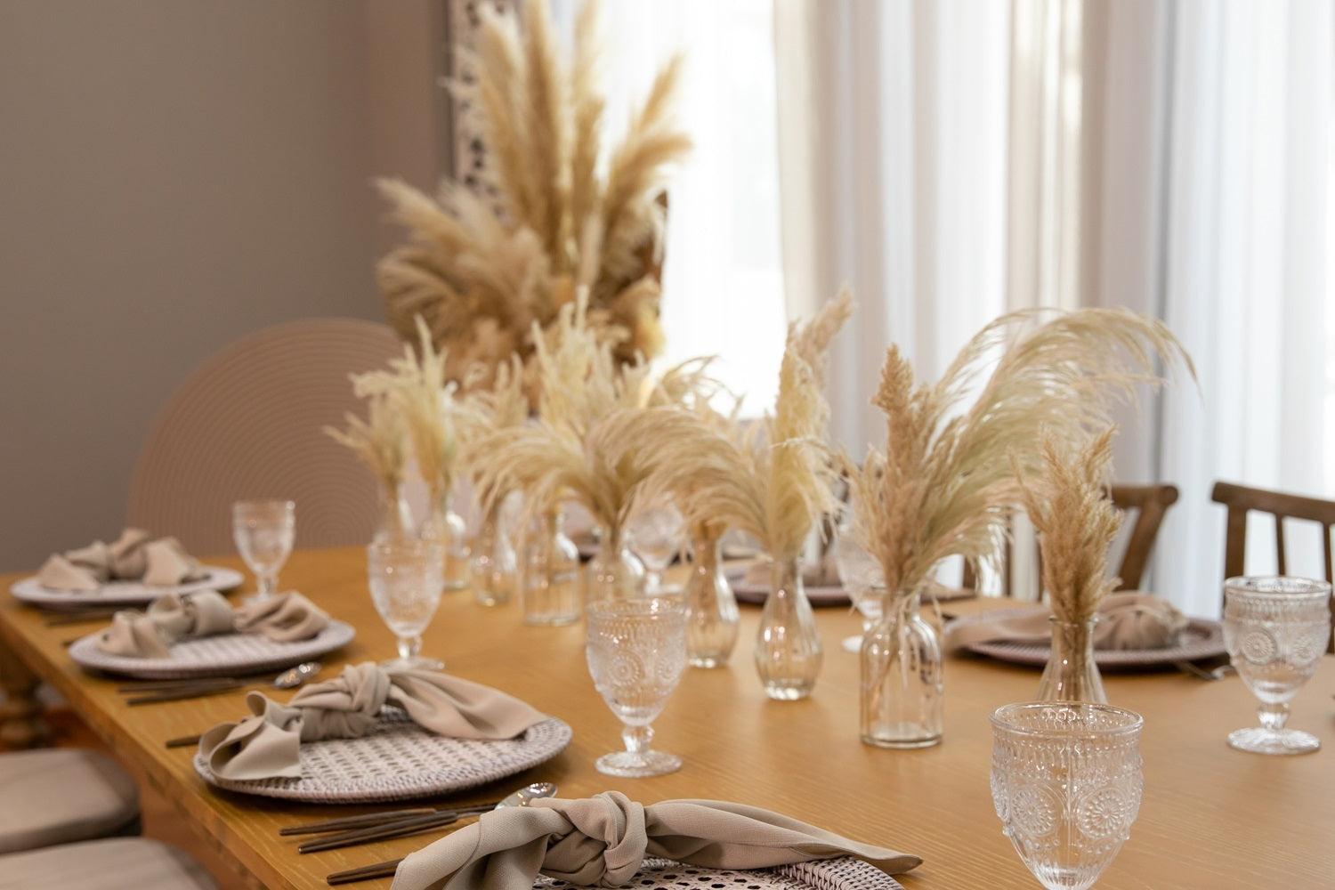 Boho &amp; Woods table setup with glasses and vases of wheat, perfect for a party of 8.