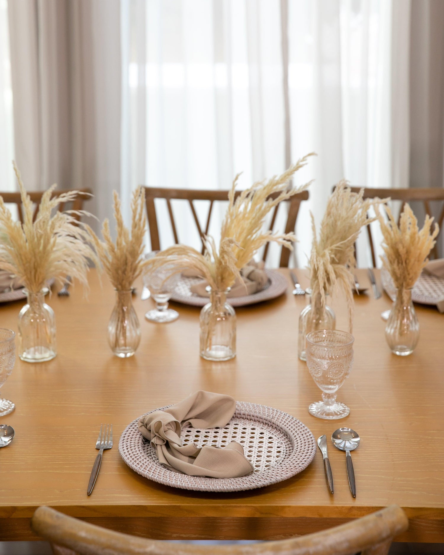 Boho &amp; Woods party package: Table with tableware, centrepieces, and glasses/vases of wheat.