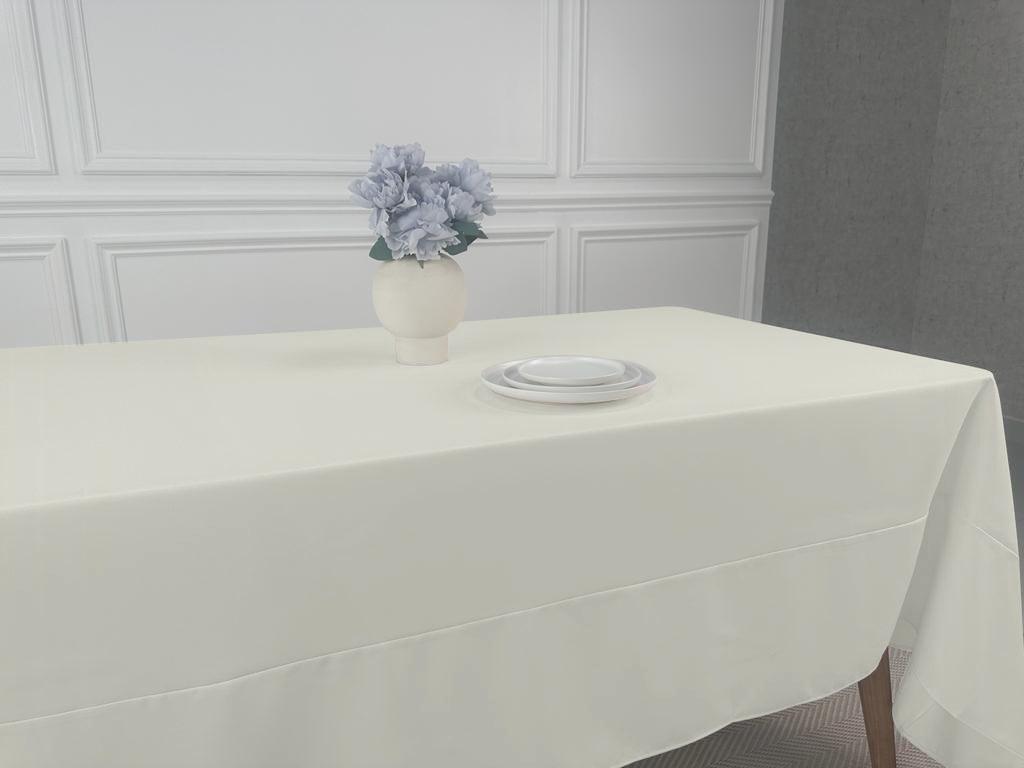 A Polycotton Tablecloth with a vase of flowers on a white table. Perfect for any event, easy to wash and reuse. Available in 3 sizes.