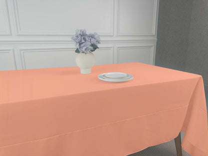 A Polycotton Tablecloth with a vase of flowers and plates on a table.