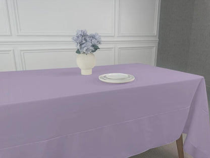 Polycotton Tablecloth with vase of flowers and stack of plates on a table