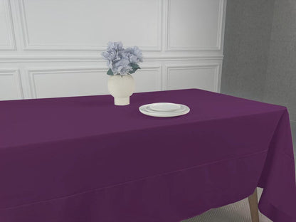 A Polycotton Tablecloth with a white plate and a vase of flowers.