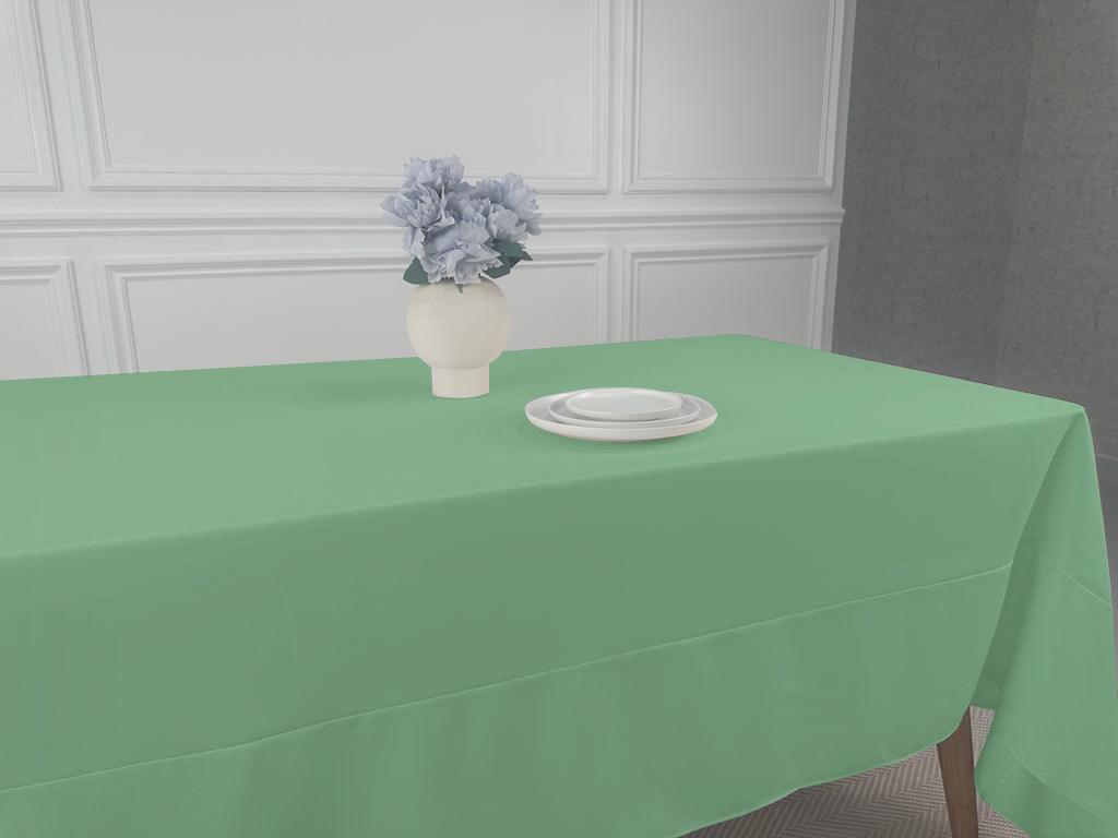 A Polycotton Tablecloth with a vase of flowers as a centerpiece on a table.