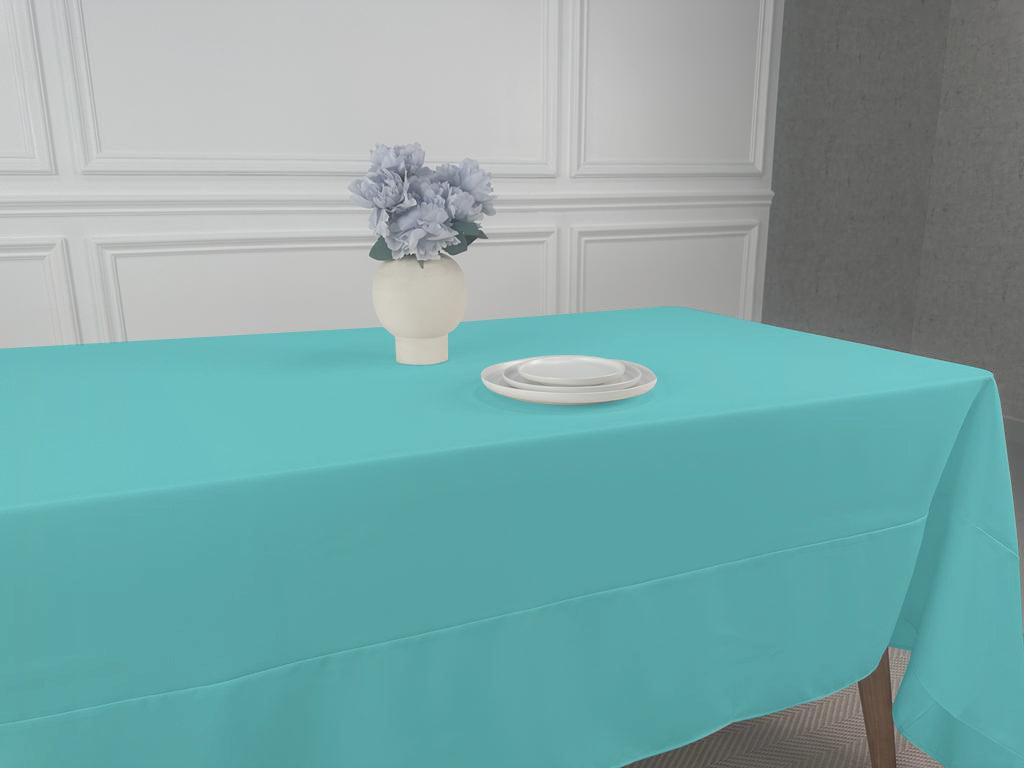 A Polycotton Tablecloth with a vase of flowers and white plates on it, perfect for any event or occasion.
